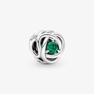 Detail of S925 silver woven charm featuring a round faceted green gemstone inlay