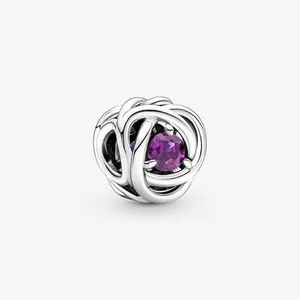 Close-up of silver braided bead charm with a centered round purple gemstone