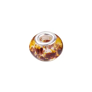 Detailed macro view of amber ink-style glass bead with silver metal core for DIY bracelets
