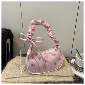 Detail of floral underarm bag with pink rose print and ruffled drawstring handle