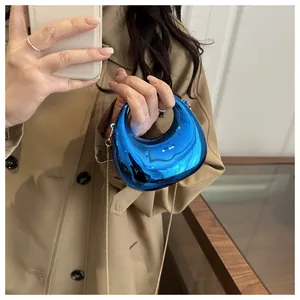 Detail view of mini crescent moon bag with blue electroplated mirror finish and gold chain