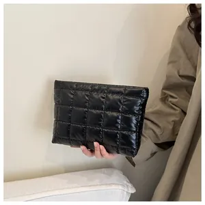 Détail de la trousse à maquillage en nylon matelassé noir brillant avec texture quadrillée
