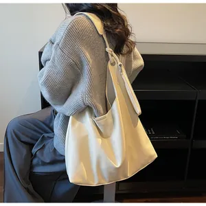 Detailed view of the creamy white soft leather texture on a large minimalist hobo bag