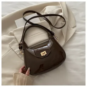 Nahaufnahme der dunkelbraunen Lackleder-Hobo-Tasche mit goldenem Drehverschluss-Detail