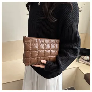 Detail of coffee brown quilted nylon cosmetic bag showing plush texture and zipper closure