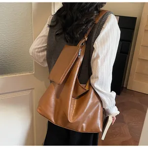 Close-up of brown PU leather tote bag and mini pouch showing texture and large capacity