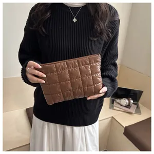 Détail d'une pochette en nylon matelassé marron avec une texture à carreaux raffinée