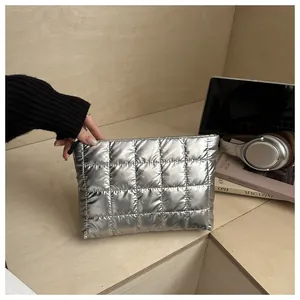 Détail de la pochette en nylon argenté matelassé avec finition métallisée et fermeture