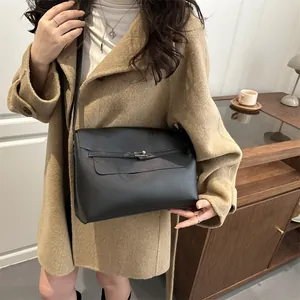 Borsa a tracolla minimalista in pelle nera con fibbia in argento indossata da una modella