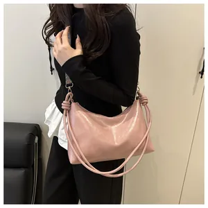 Detail of pink pearlescent tote with knot handle and vintage ethnic shoulder strap