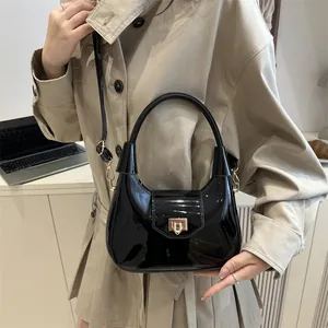 Glänzende schwarze Halbmond-Handtasche mit Goldschloss und abnehmbarem Gurt