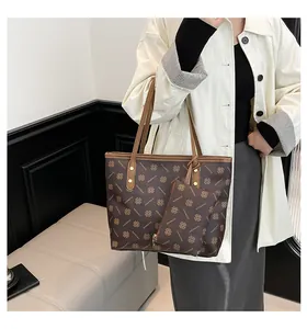 Detail of monogram tote bag with matching pouch and polished gold-tone rivets