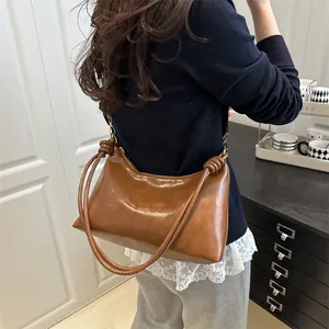 Classic caramel brown tote bag in shiny leather featuring a knotted shoulder strap detail