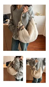 Detail of plush off-white hobo bag featuring faux rabbit fur and leopard heart charm
