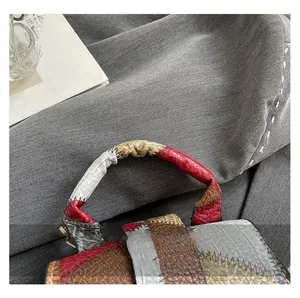Close-up of contrast color patchwork handle with snakeskin texture and gold ring hardware