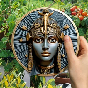 Detailed view of an ancient Egyptian goddess iron garden plaque among outdoor plants