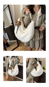 Detailed view of white faux fur tote bag with leopard print pom pom and gold metal hardware