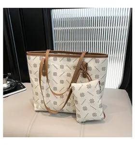 Detail view of large cream tote bag set with brown leather handles and inner pouch