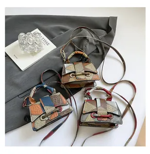 Detailed view of color-blocked faux animal skin crossbody bags with vintage metal hardware