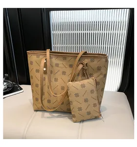 Detail view of khaki tote and small zippered pouch with clover pattern and lettering