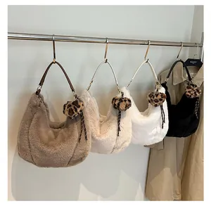 Detail view of winter plush tote bags in four colors with leopard print heart pendants
