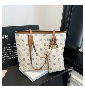 Detail of white tote bag with brown clover pattern and matching small pouch