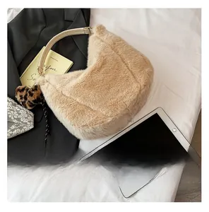 Detail of plush beige shoulder bag with faux fur texture, leather handle and leopard charm