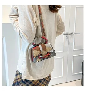 Detail shot of a color-block crossbody square bag worn by a model in a minimalist setting