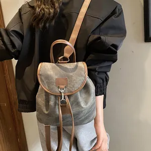 Retro canvas backpack with contrasting leather trim and metallic buckle closure