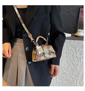 Model wearing a small color-block square bag with crocodile texture and gold metal ring