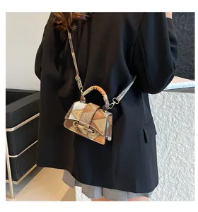 Modern crossbody flap bag with geometric color-block design shown on a female model
