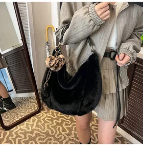 Detail of black faux fur shoulder bag featuring a leopard heart charm and leather strap