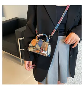 Detail of color-block mini handbag featuring exotic snake and crocodile textured leather