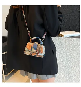 Detail showing colorful patchwork crossbody bag with crocodile and lychee leather textures