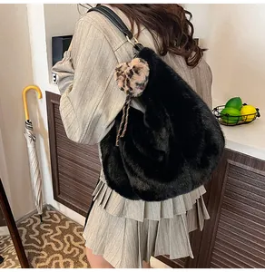 Detail of black faux fur hobo bag featuring a leopard heart pendant and leather strap