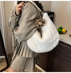 White faux fur hobo bag featuring leopard heart charm and checkered woven shoulder strap