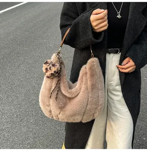 Detail of faux fur tote bag in dusty pink with plush leopard heart charm and chain strap