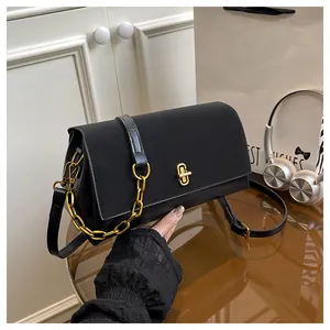 Detail of black leather crossbody bag with golden twist lock and elegant chain strap