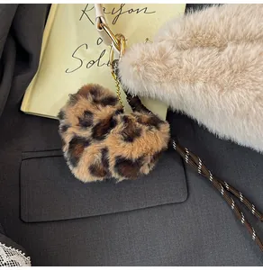 Detailed close-up of a leopard print plush heart pendant with golden metal ring and lanyard