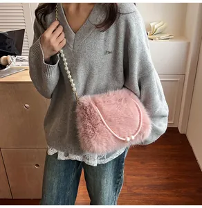 Detail of pink faux fur plush handbag featuring an elegant pearl and gold chain strap
