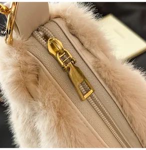 Close-up of golden metal zipper and soft beige faux fur texture on the winter tote bag