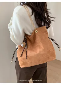 Borsa tote in camoscio marrone con tracolla a catena dorata sulla spalla