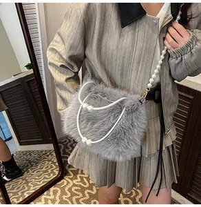 Detail of grey plush crossbody bag featuring faux pearl handle and elegant chain strap