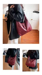 Detail of vintage dark red tote bag featuring metal buckle and textured leather finish
