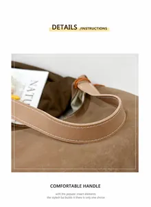 Dettaglio del manico della borsa tote in pelle scamosciata con cuciture bianche di pregio
