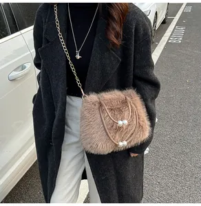 Close-up of brown faux fur handbag featuring elegant pearl accents and gold chain strap