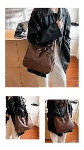 Detailed macro view of retro brown hobo bag with vintage metal buckle and key pendant decor