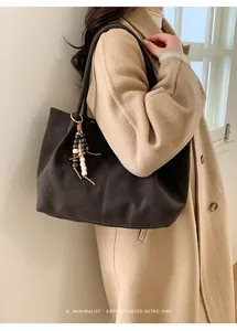 Detail of dark brown matte suede tote bag with stylish wooden bead accessory