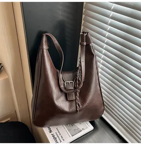 Detail of vintage dark brown hobo bag with retro texture and striped knot charm