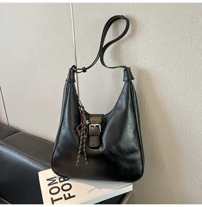Detail of a vintage black hobo bag with textured leather and adjustable shoulder strap